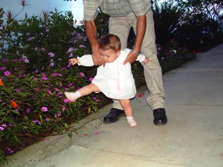 a little girl takes big steps with the help of  her grandfather
