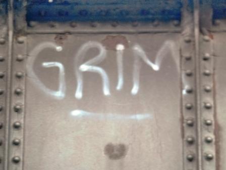 the word grim spray-painted on a bridge