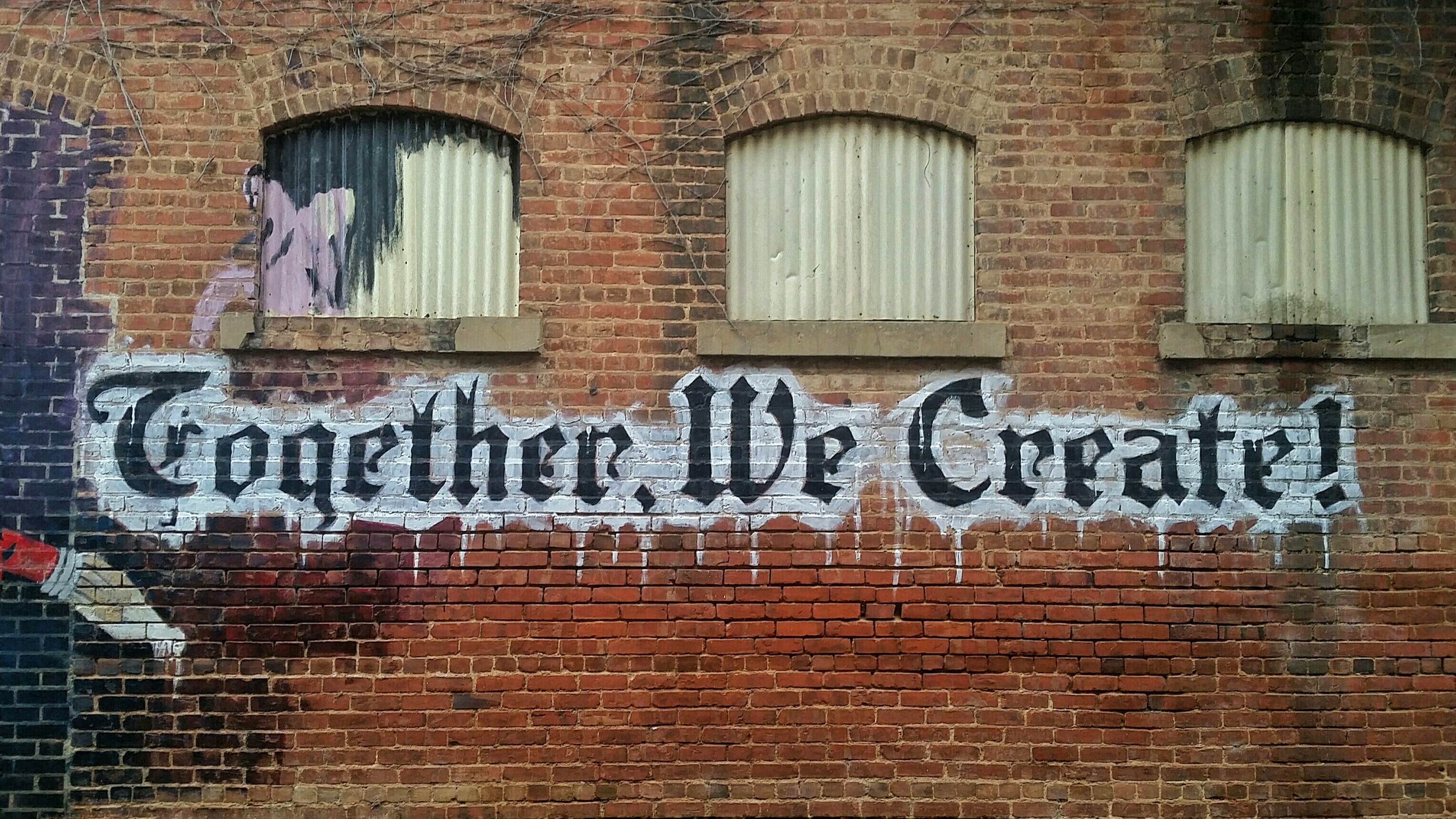 Together We Create! written on an old wall